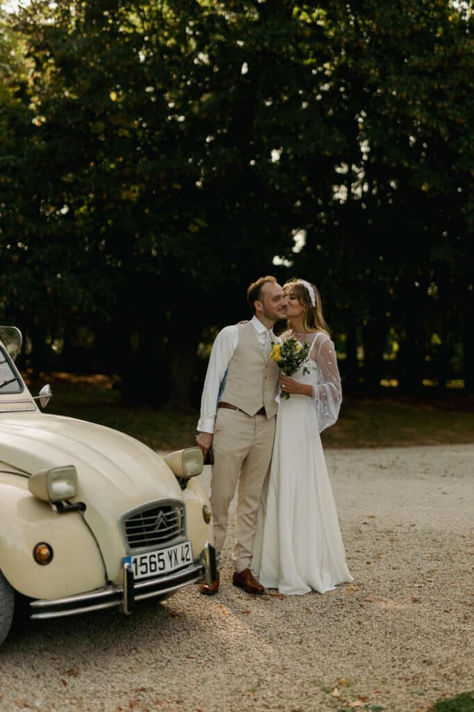 mariés avec voiture coccinelle dans un domaine en forêt